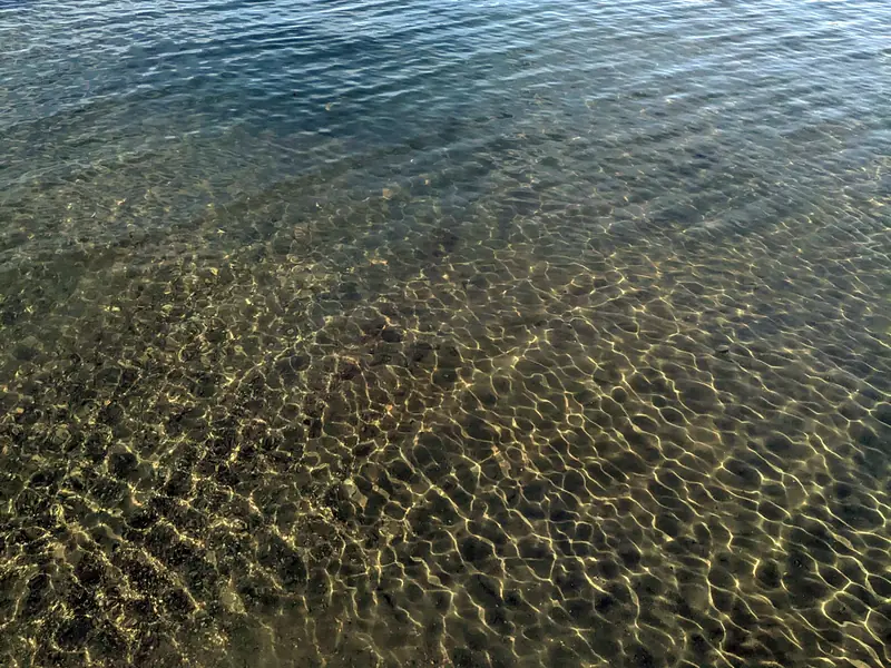 The clear, shallow water of Kalamalka Lake on a calm summer day